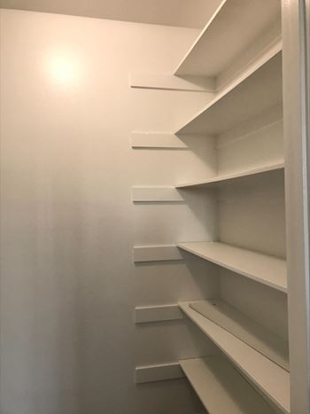 Empty white shelves in a room.